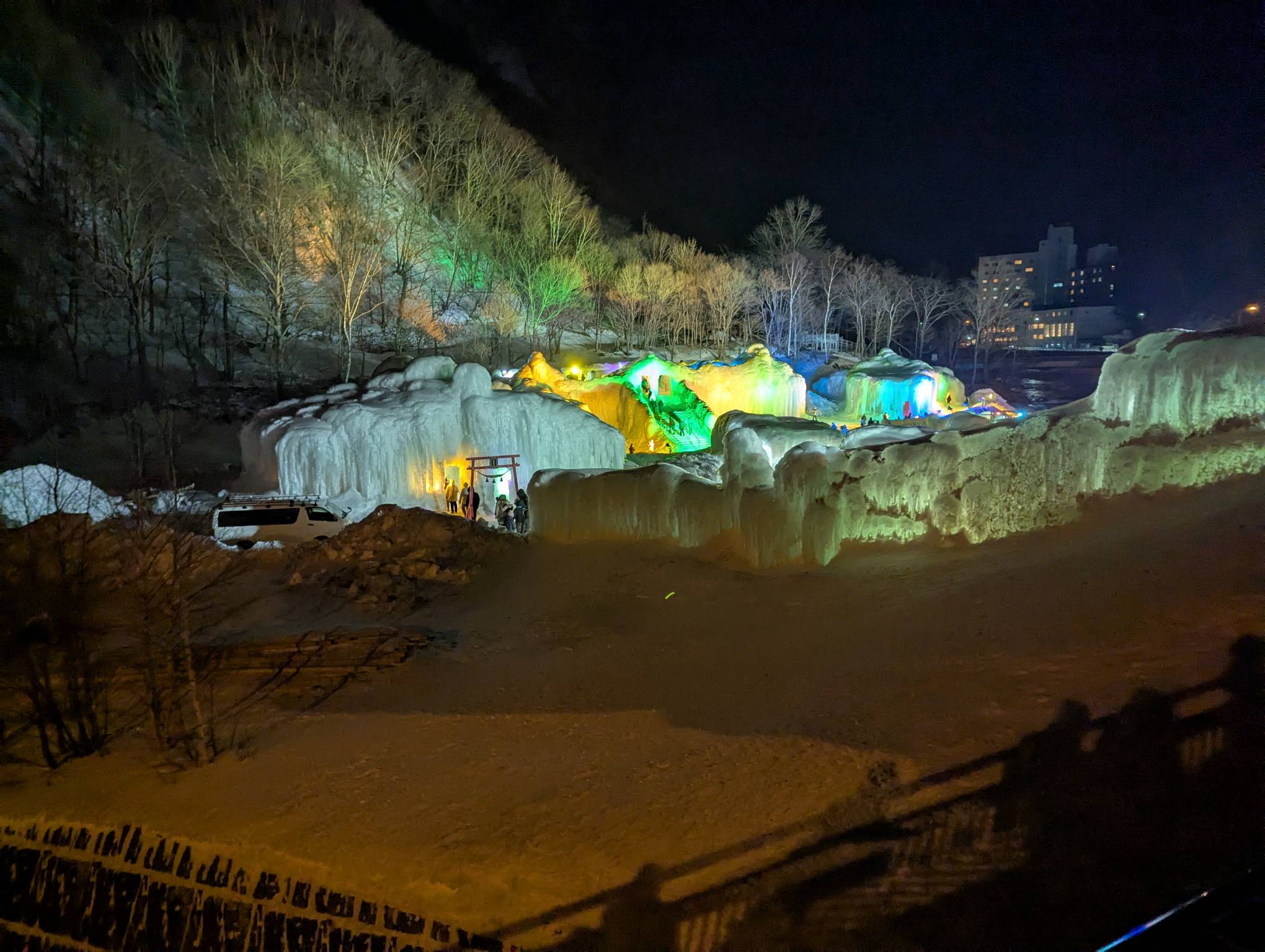 游客在温泉中享受冰雕美景